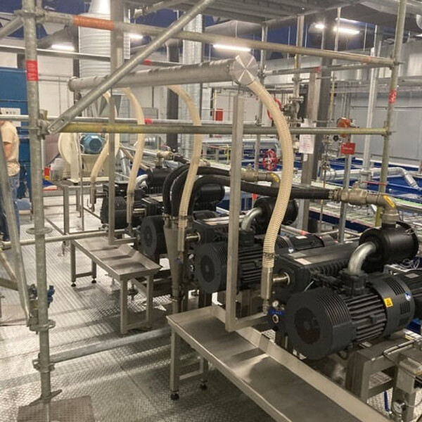 Grotere RVS lekbakken/opvangbakken onder de pompunits om olielekkage op te vangen.