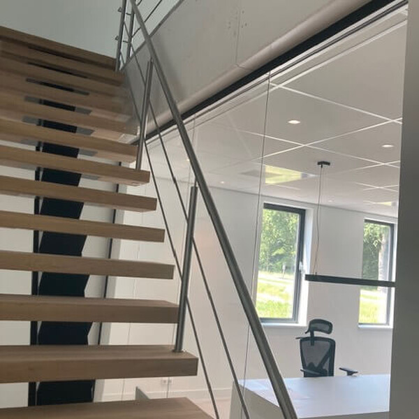 Traptreden beschermd met karton tijdens montage van de RVS leuning.